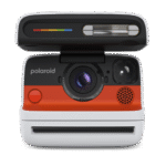 Una cámara Polaroid. Tiene un botón rojo y un flash. La cámara es blanca y naranja.