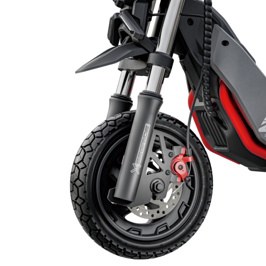 Primer plano de la rueda delantera de un patinete eléctrico negro y rojo. Fondo negro.